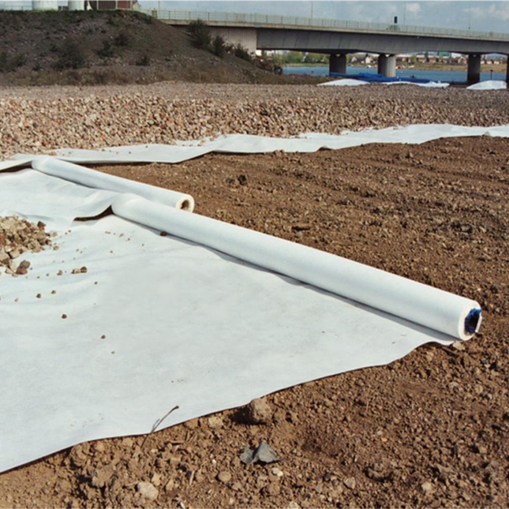 weißes Filtervlies ausgerollt auf Schotter Sandgemisch