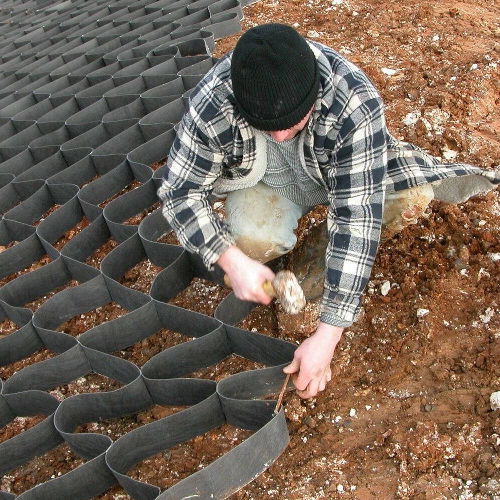 Mann bei der Befestigung von Geozellen mit J-Pins