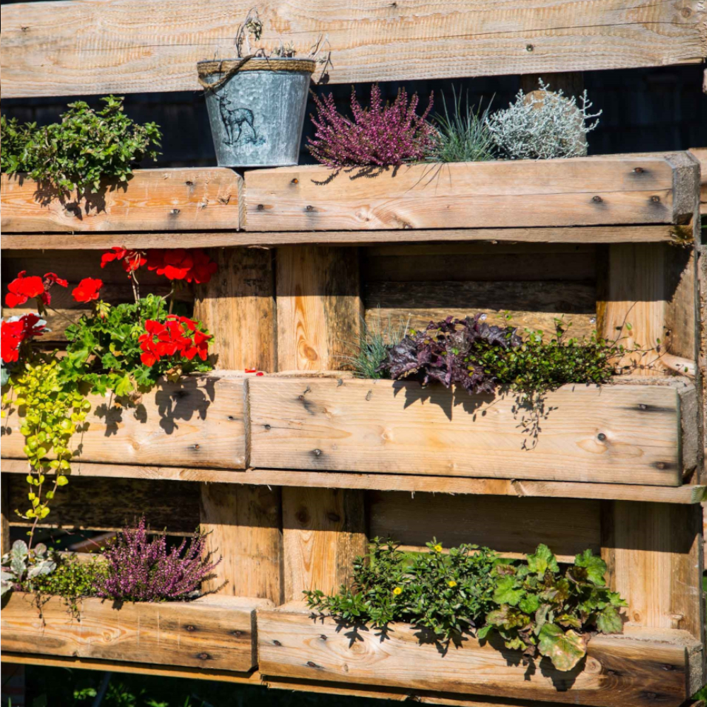 Paletten-Blumenbeet mit dem Blumenkastnvlies geschützt