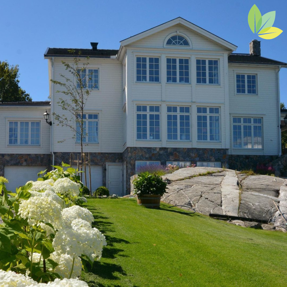 Garten mit grünem Rasen und Haus im Hintegrund