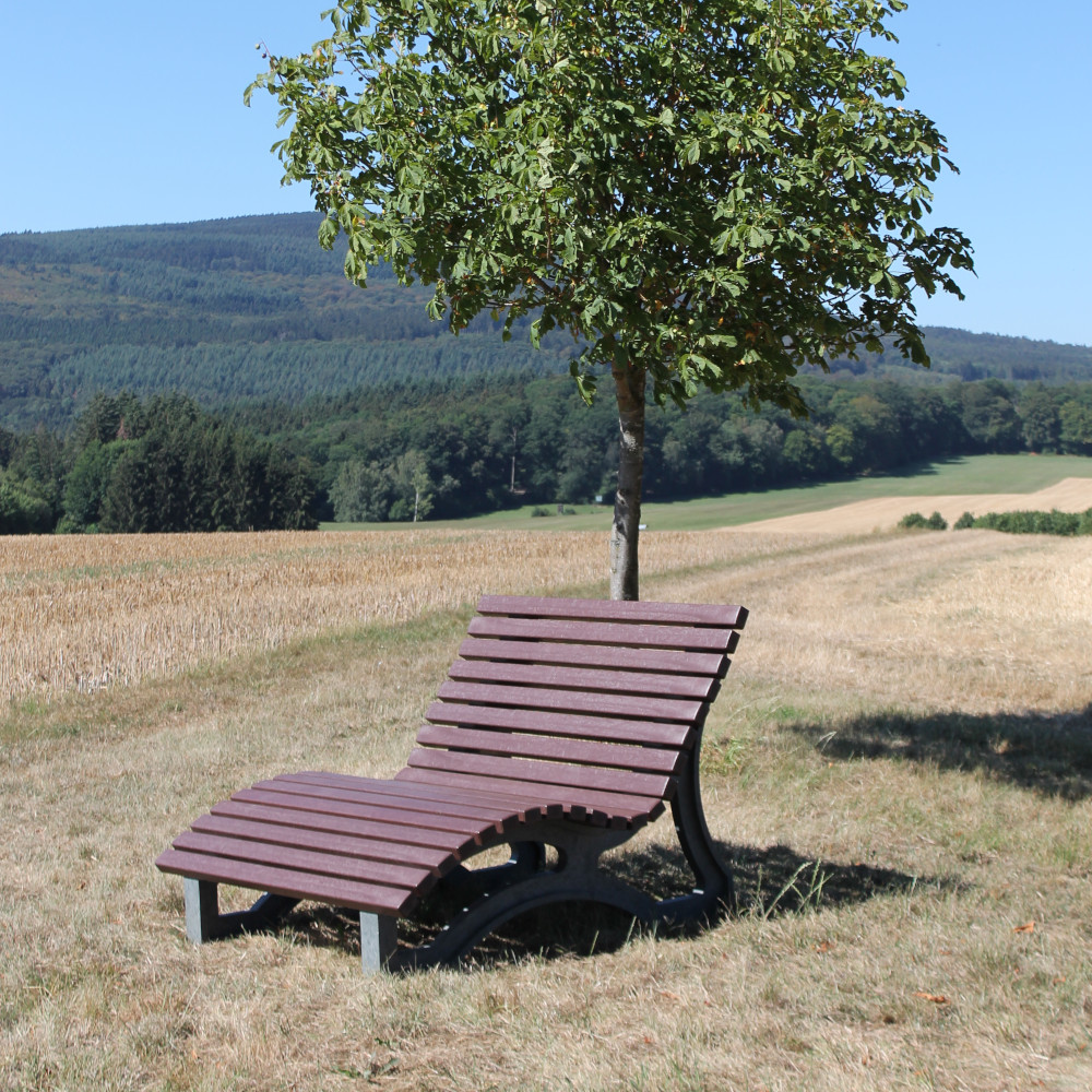 braune Liegebank Aveto im Feld unter einem Baum