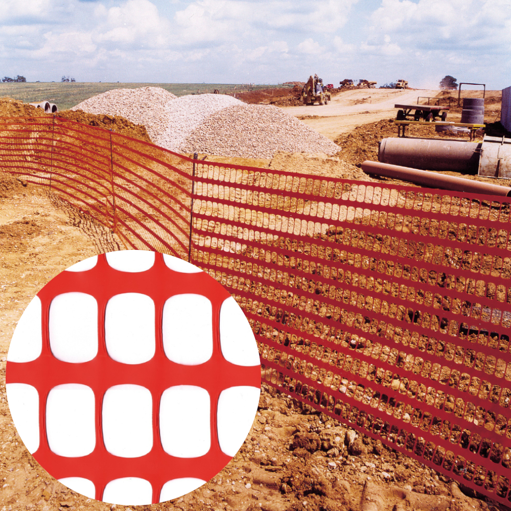 oranges Gitternetz aufgestellt vor Baustelle mit Kiesbergen
