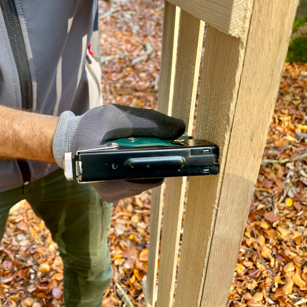 Pure Nature Wuchshülle Pure Nature Holz-Wuchshülle wird an Hartholzpfahl getackert für Aufbau