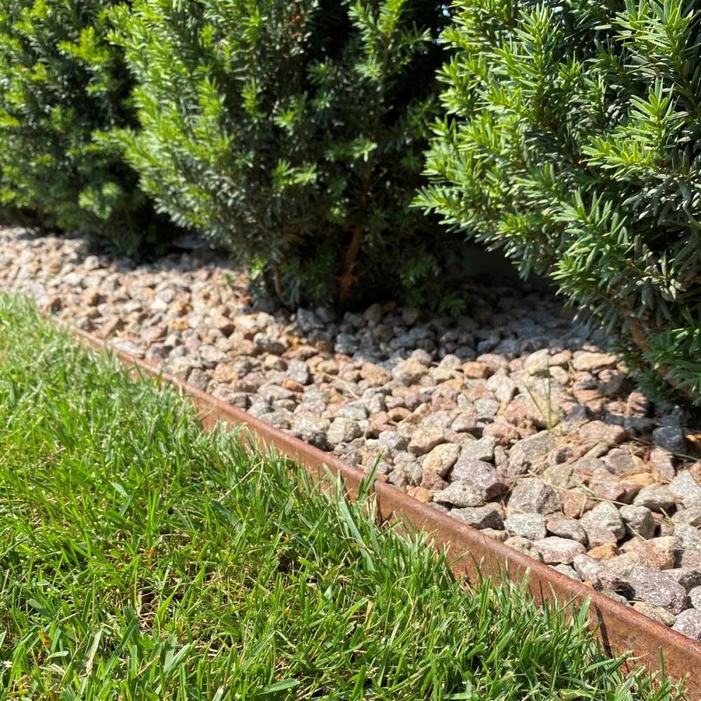 Rasenkante aus Cortenstahl trennt Rasen und Kies