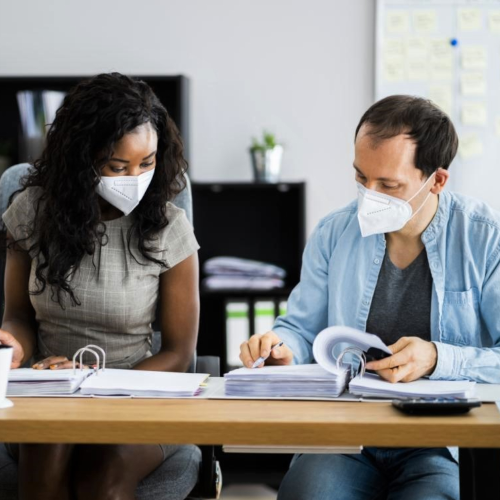 Zwei Personen tragen im Büro FFP2 Masken