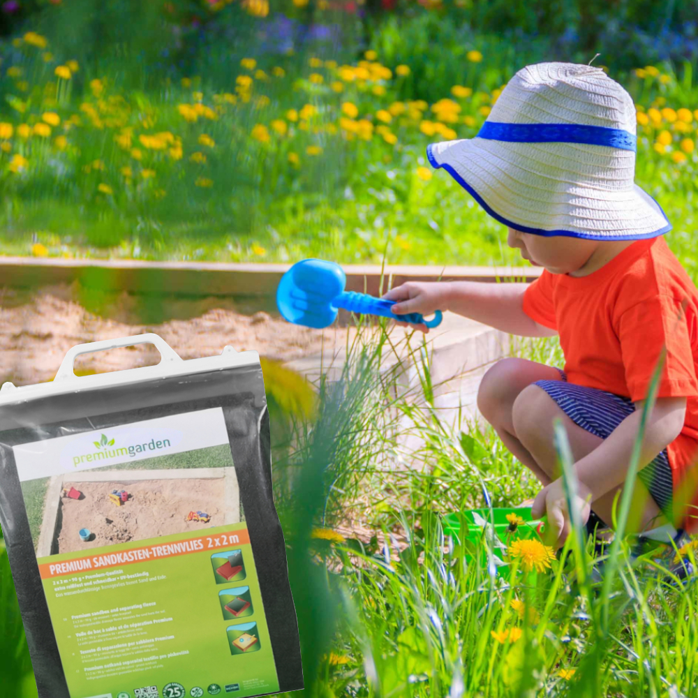 Ein Kind in einem Garten spielt im Sandkasten mit einer blauen Schaufel. Im Vordergrund liegt ein Sack mit Spielsand.