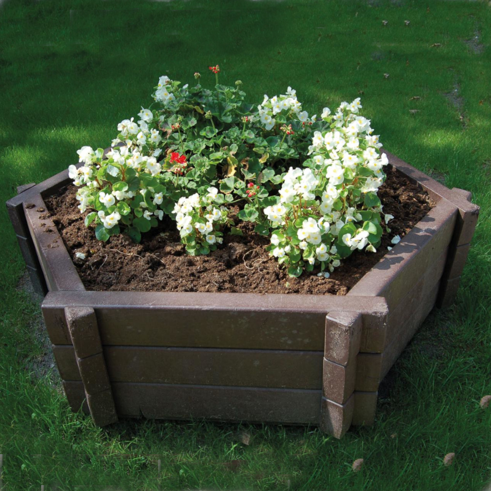 brauner sechseckiger Blumenkübel mit Bepflanzung auf Wiese