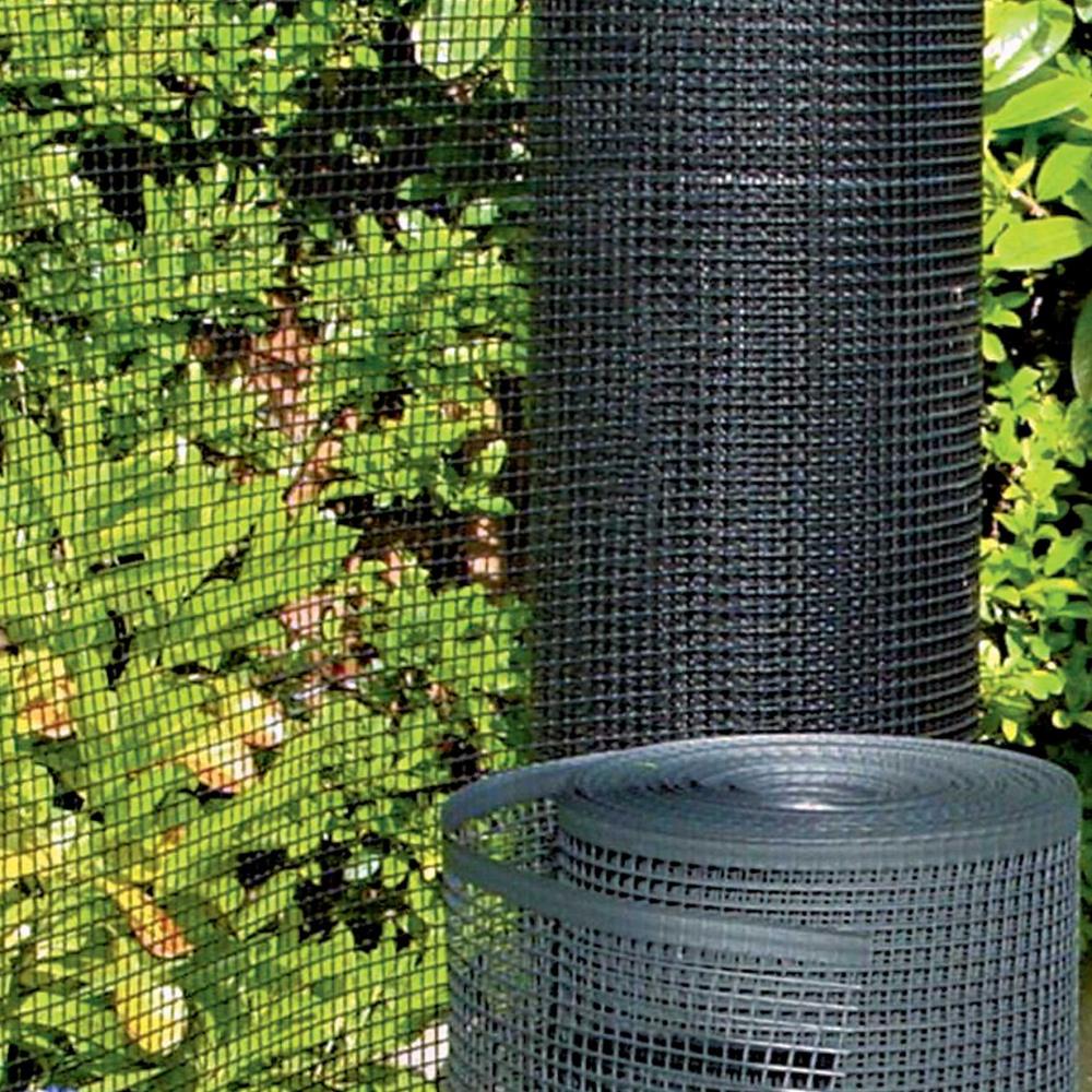 Grüner Kunststoffzaun, aufgerollt vor grünem Laub, glatt Webkante sichtbar