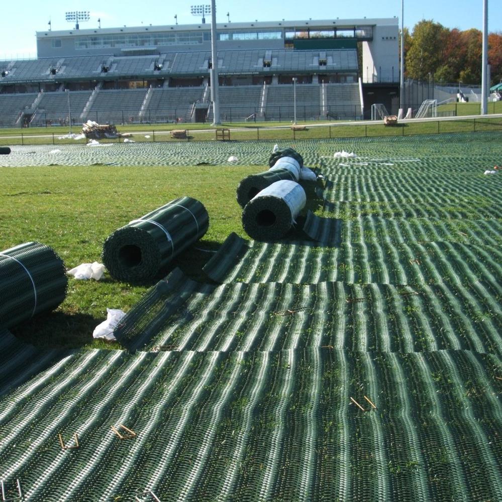 Ausrollen des Rasengitters auf Sportplatz