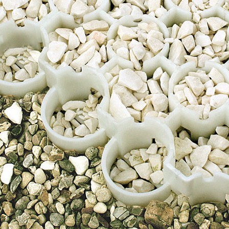 Weißes Rasengitter mit groben Kies